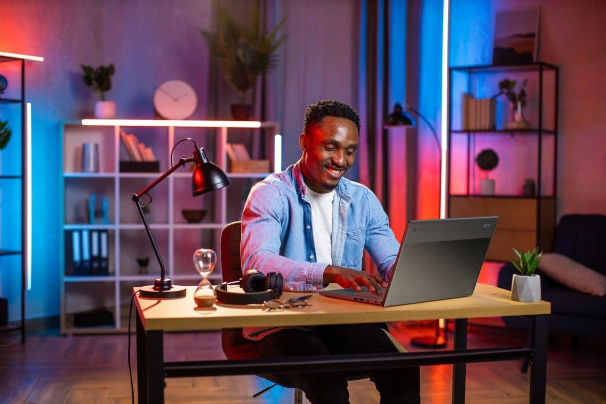 Ένας εργαζόμενος στο σπίτι κάθεται σε ένα γραφείο και εργάζεται σε ένα φορητό υπολογιστή