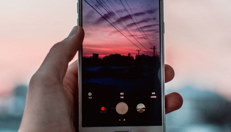 Person taking a picture of the sunset with mobile phone hero image