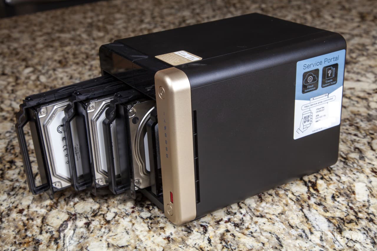 Corner picture of the QNAP TS-464 with three drive sleds slightly out