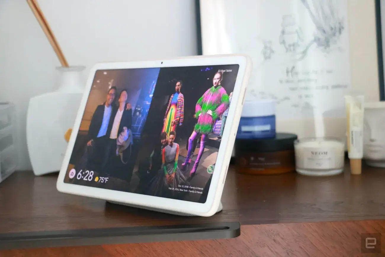 Πλάγια όψη του Pixel Tablet, που δείχνει δύο φωτογραφίες στην οθόνη του ως μέρος της λειτουργίας κορνίζας φωτογραφιών.