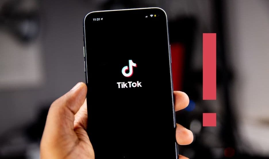 Person holding a phone with the TikTok logo on the screen