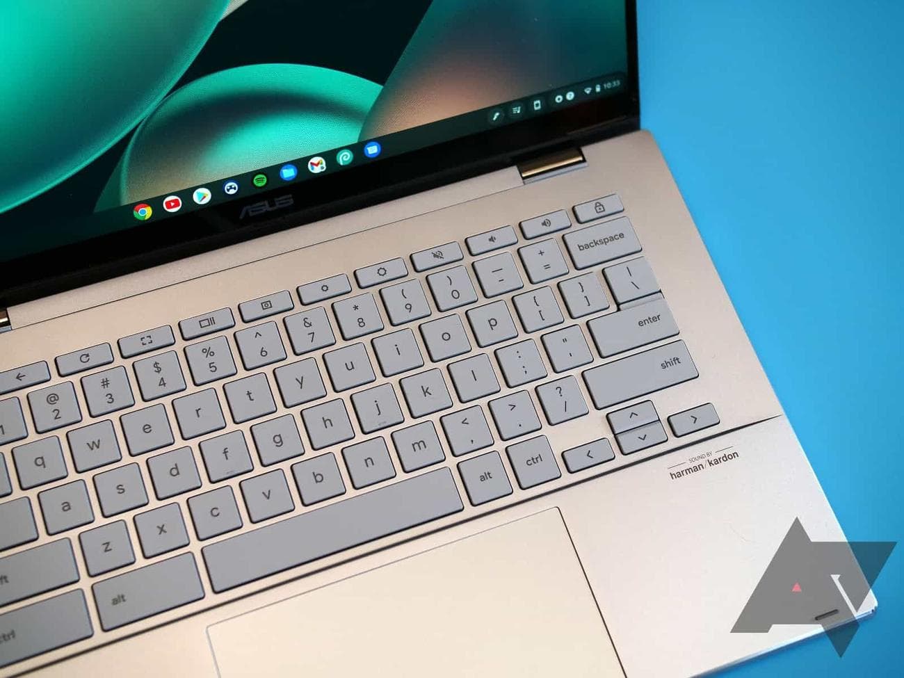 Ένα Asus Chromebook Flip CX5 με γαλαζοπράσινο φόντο με τονισμένο το πληκτρολόγιο