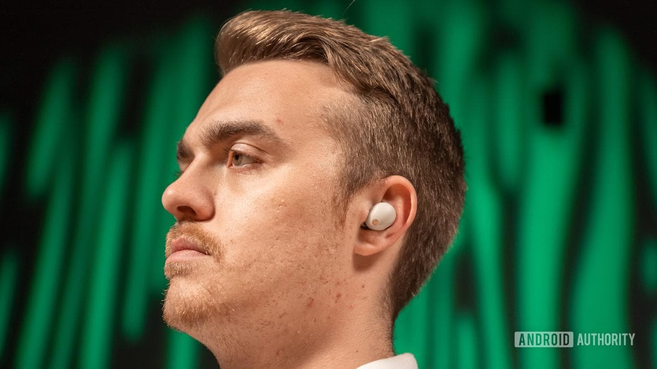 A man wears the Sony WF 1000XM5 and looks away.