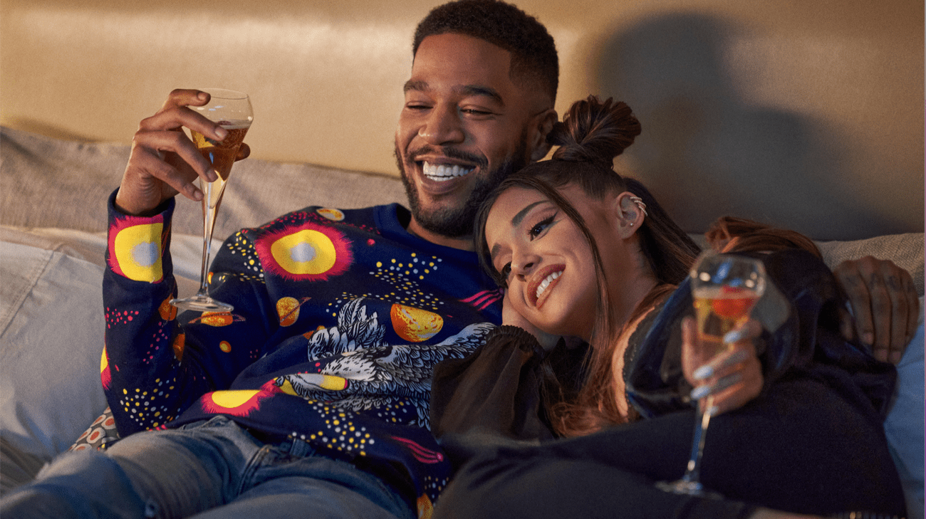 Ένα ζευγάρι αγκαλιά σε έναν καναπέ πίνοντας κρασί. 