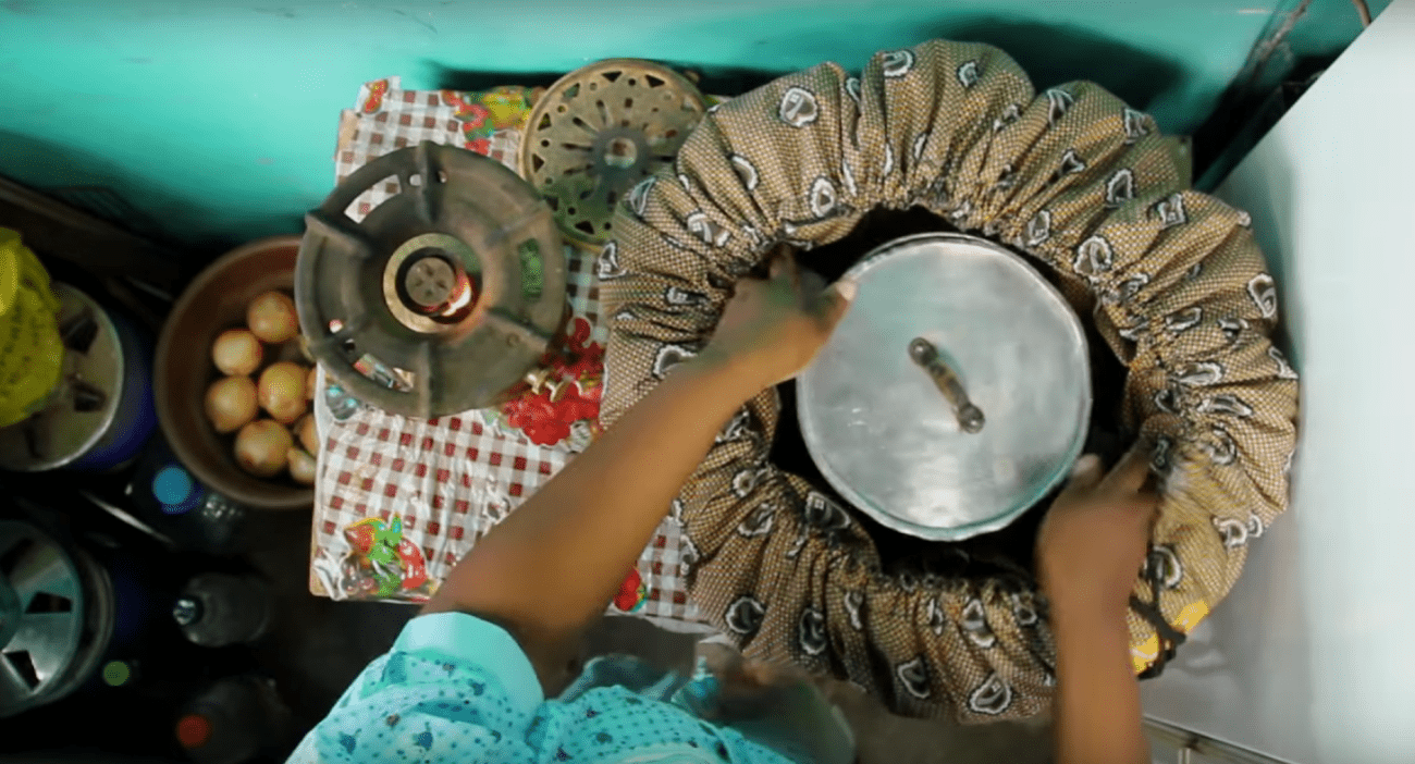 A person putting a pot in a Wonderbag.