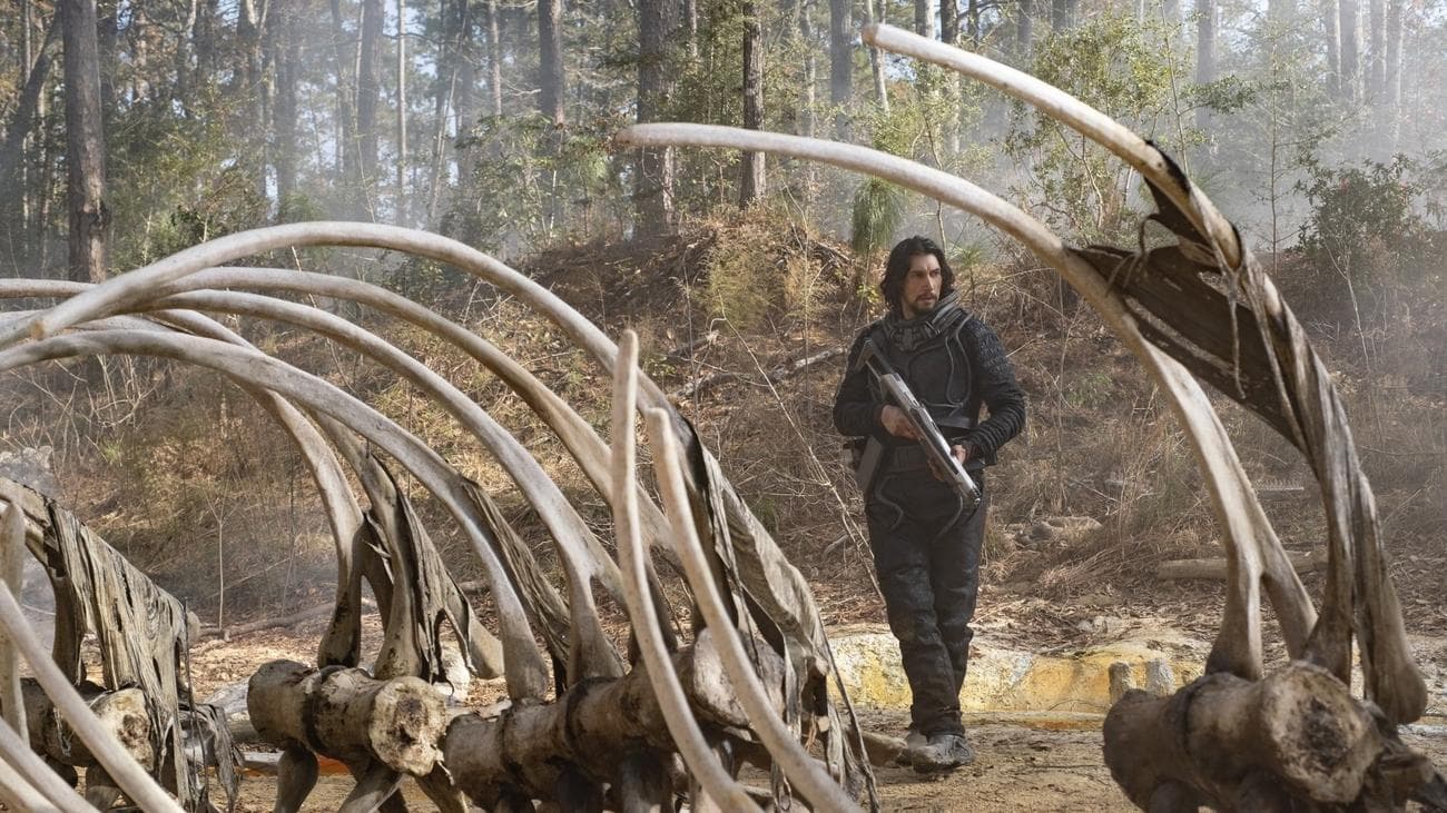 Ένας άντρας περπατά ανάμεσα σε γιγάντια οστά δεινοσαύρων. 