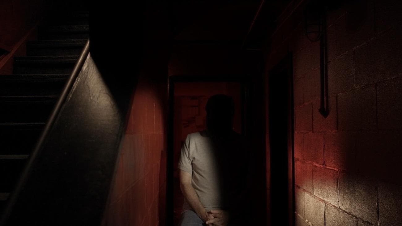 Ένας άντρας που κάθεται στη σκιά δίπλα σε μια σκάλα.