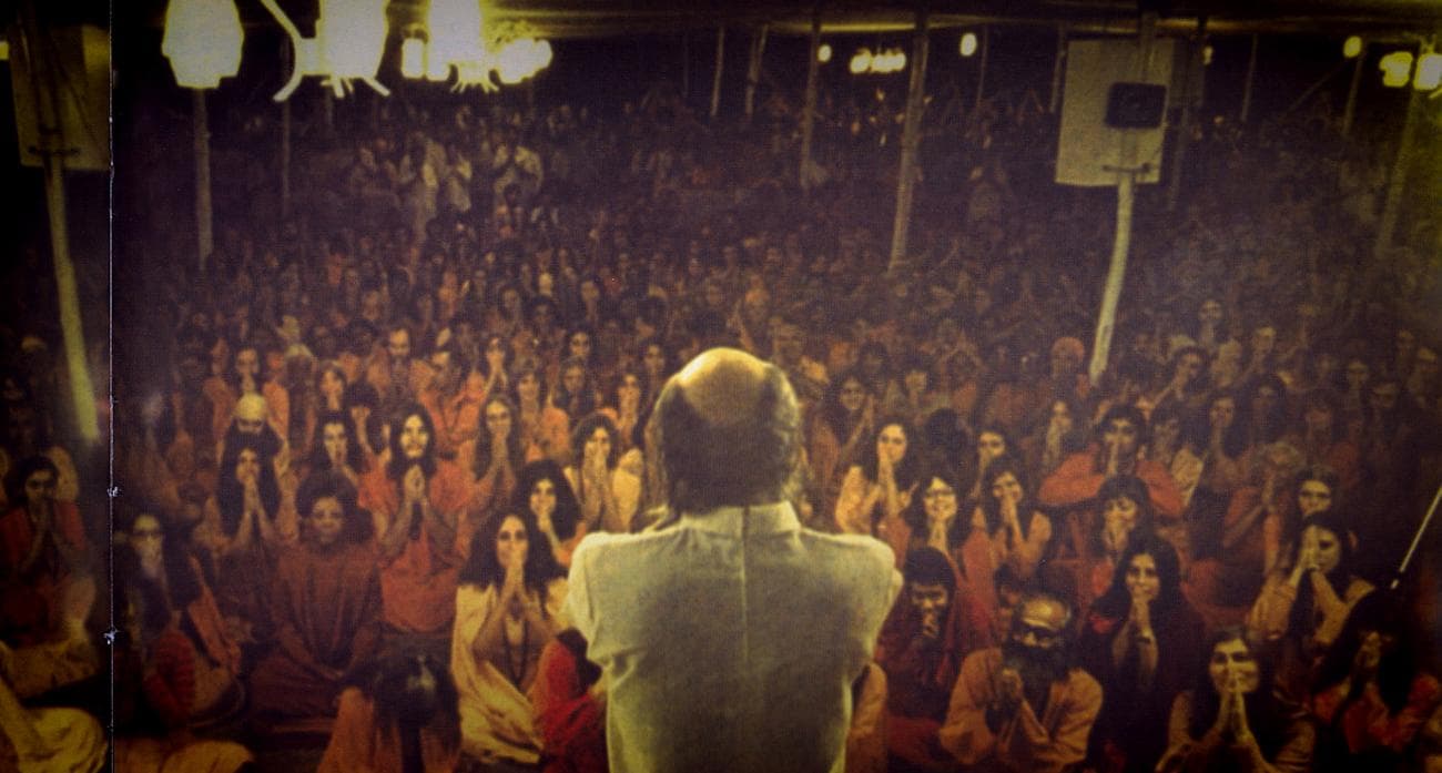 The Rajneeshpuram commune is addressed by their leader Bhagwan Shree Rajneesh.