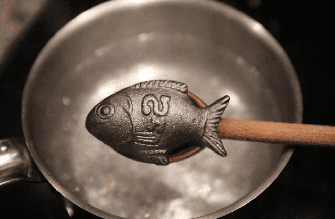 A Lucky Iron Fish above a pot of boiling water.