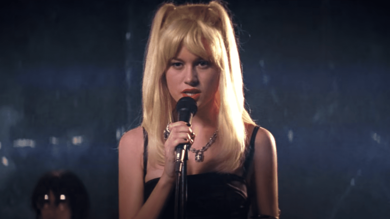 Μια ξανθιά γυναίκα τραγουδά στη σκηνή. 