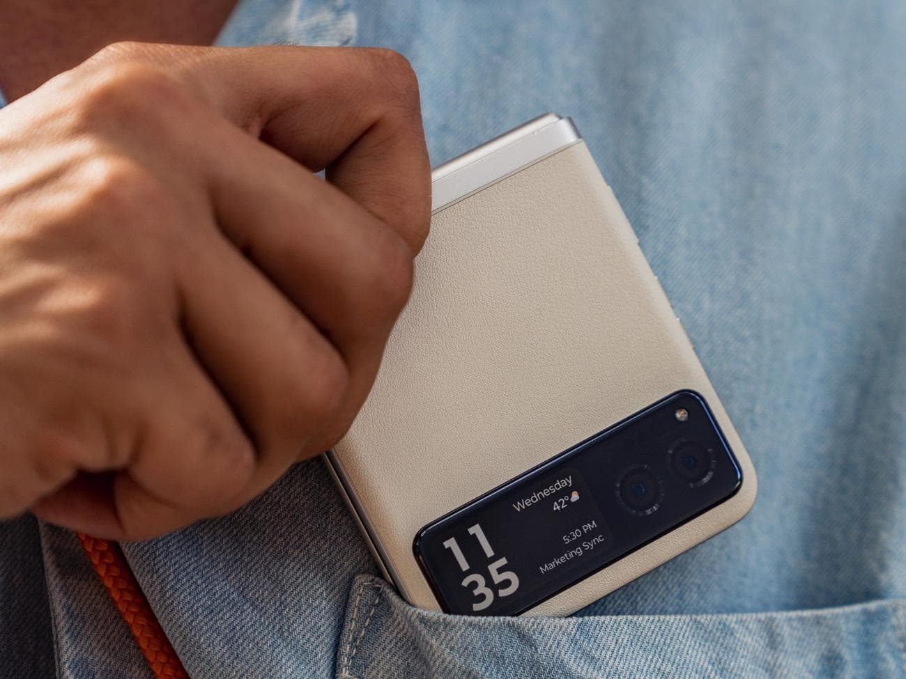 Ένα άτομο που βάζει ένα Moto Razr στην τσέπη του πουκαμίσου του