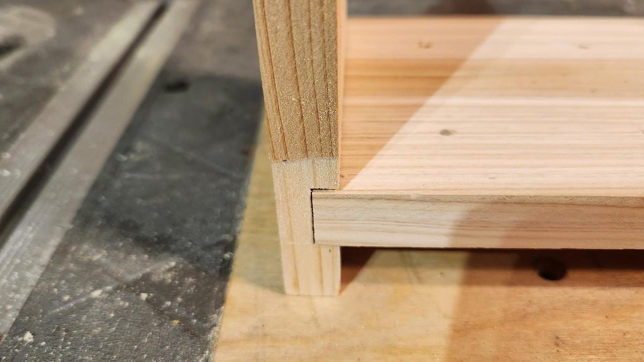 A close up on a squared joint in a piece of wooden furniture using dados.