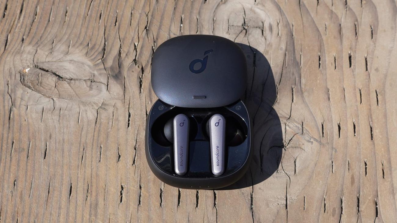 Anker Soundcore Liberty Air 2 Pro sitting in their case on a wood surface with the lid open.