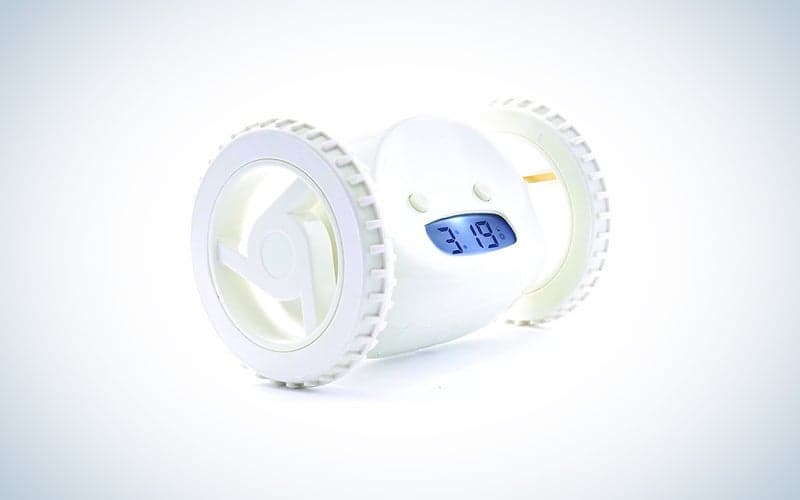 A white alarm clock with wheels on a blue and white background