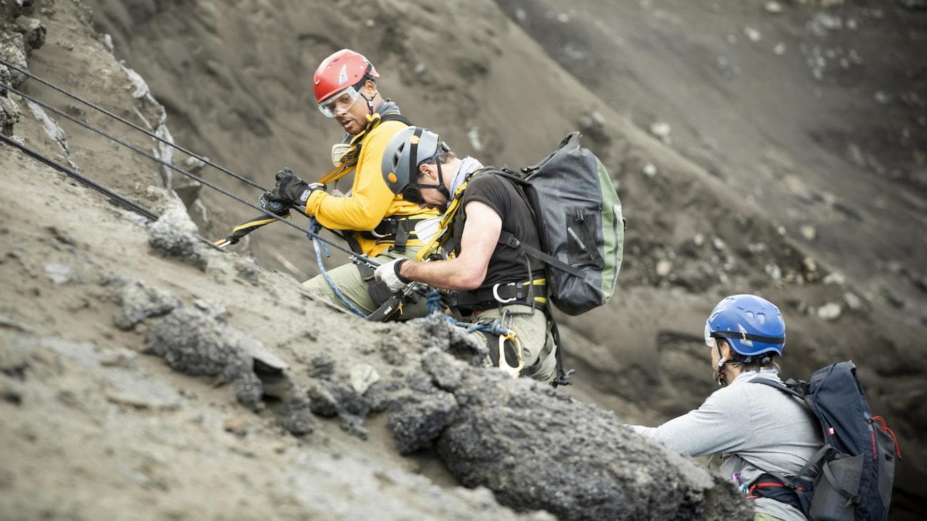 Will Smith, vulcanologist Jeff Johnson, and explorer Erik Weihenmayer descend into a volcano to install sensors. 