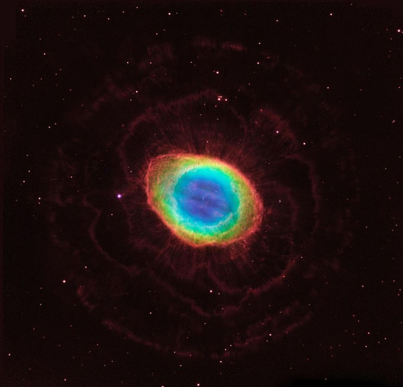 Σε αυτή τη σύνθετη εικόνα, παρατηρήσεις ορατού φωτός από το διαστημικό τηλεσκόπιο Hubble της NASA συνδυάζονται με υπέρυθρα δεδομένα από το επίγειο Μεγάλο Διόφθαλμο Τηλεσκόπιο στην Αριζόνα για να συγκεντρώσουν μια δραματική άποψη του γνωστού Νεφελώματος Δακτυλίου.