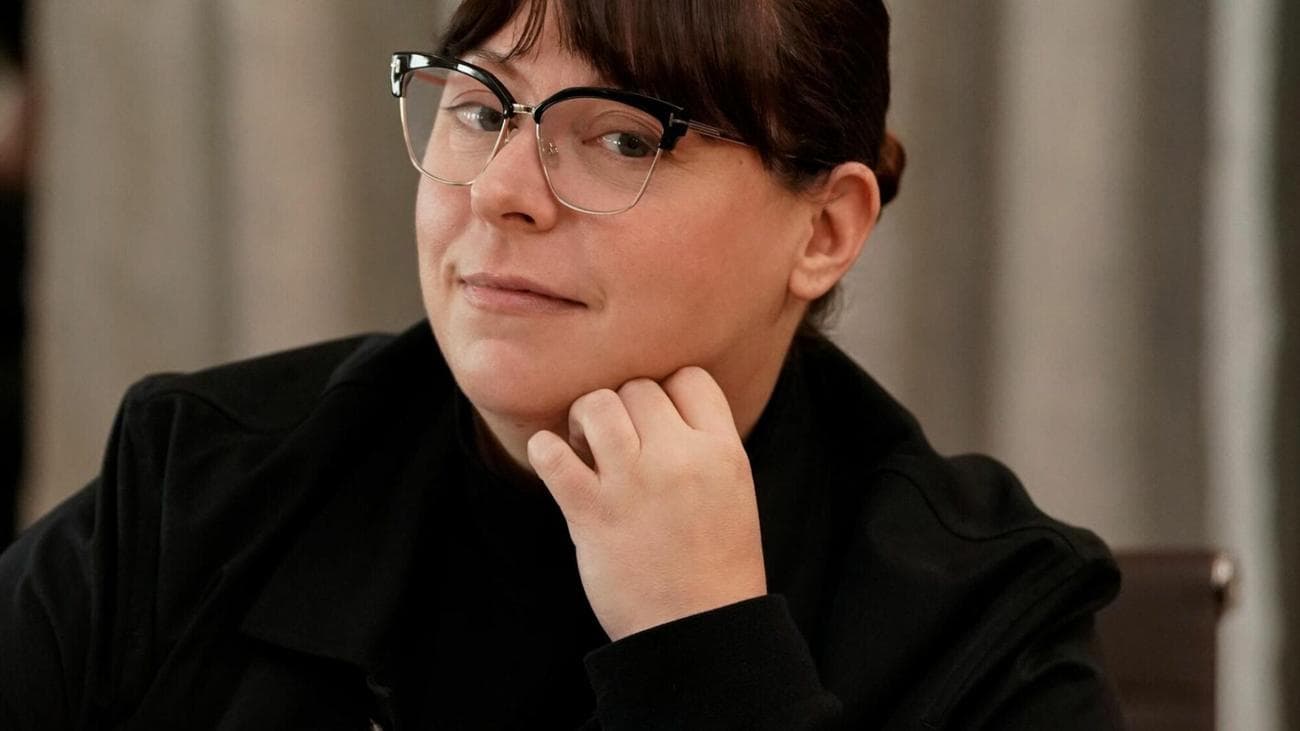 A woman wearing glasses and a black jacket. 