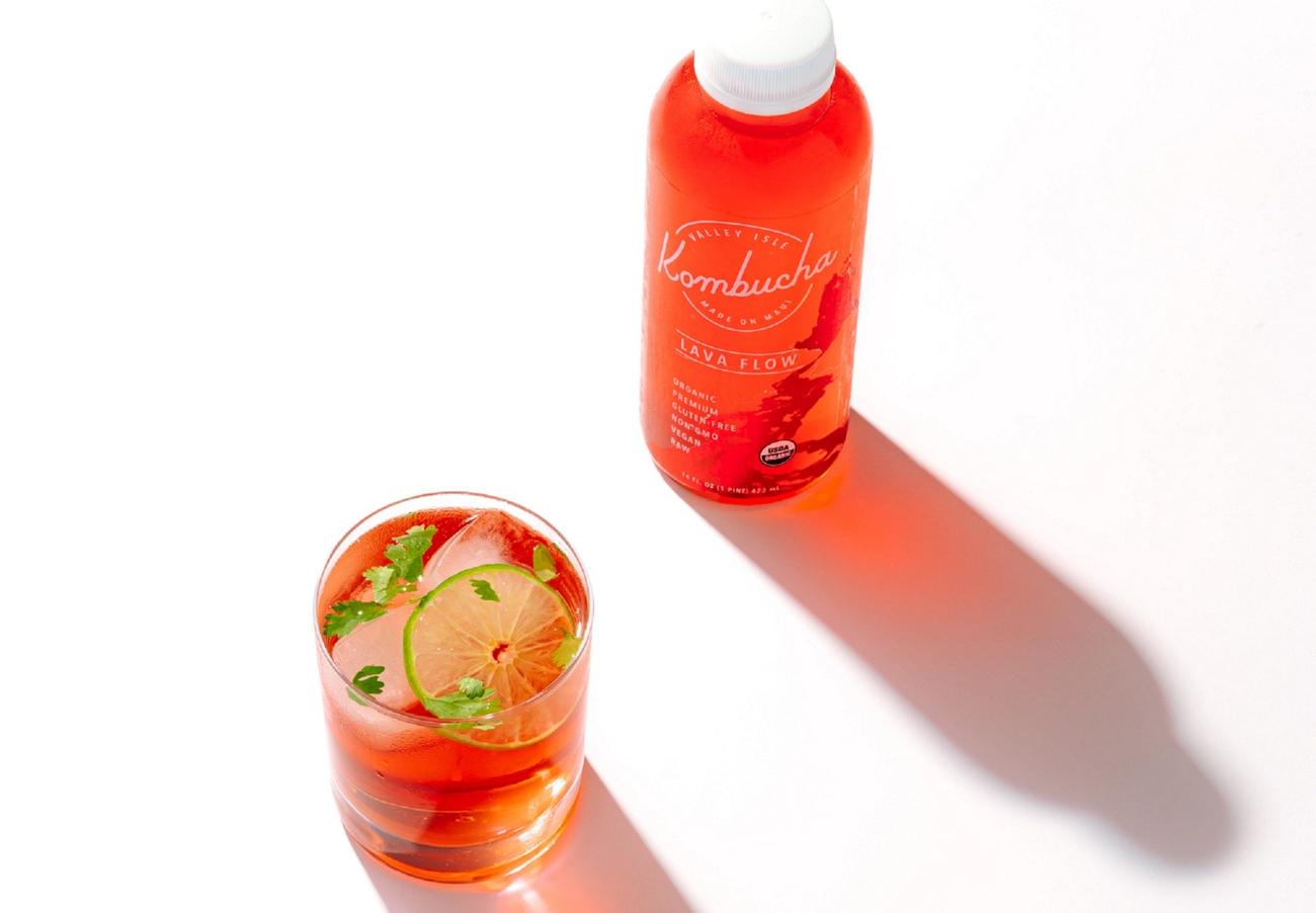 Red kombucha tea in a bottle and glass on white background