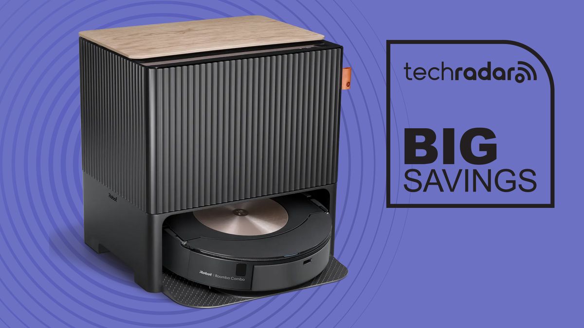 The Roomba Combo j9+ in its self-emptying charging dock next to a sign reading 