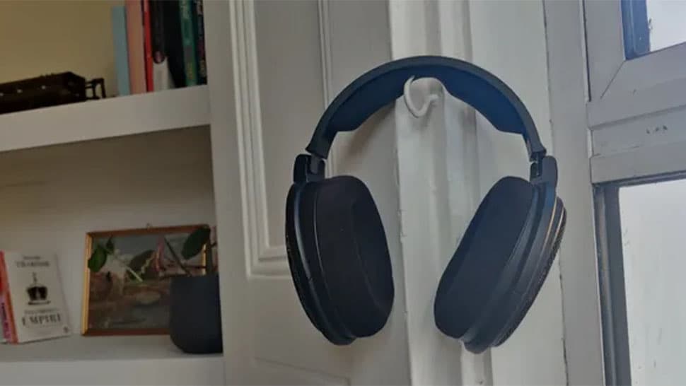 Τα ενσύρματα ακουστικά Sennheiser HD 660S2 κρέμονται σε ένα γάντζο.