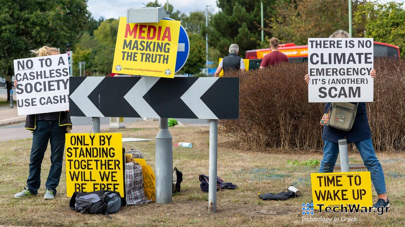Conspiracy theorists protest at a busy roundabout in the village of Martlesham in Suffolk, England.