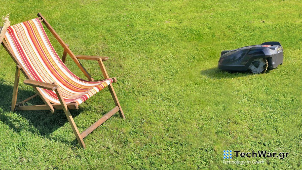 Robot lawnmower cutting grass around a deckchair