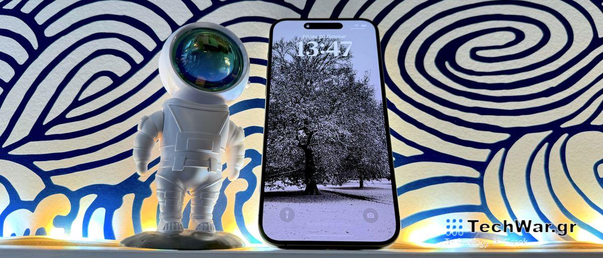 An iPhone 15 Pro Max against an abstract blur swirling background.