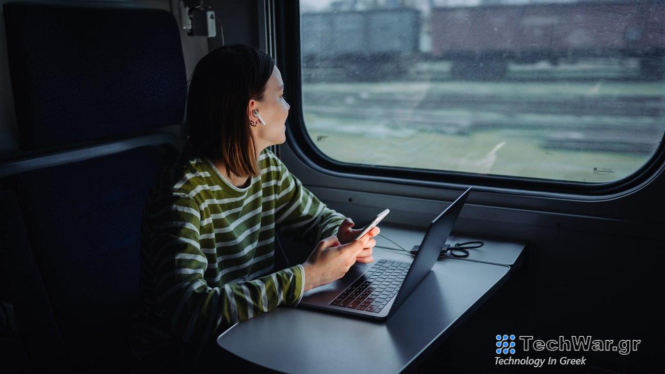 woman sitting on train using laptop and computer