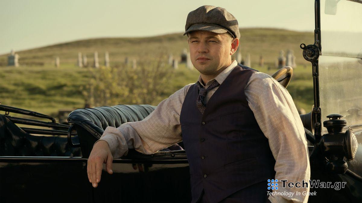 Leonardo DiCaprio leaning against a car