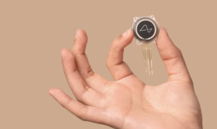 Image of a hand holding Neuralink implant