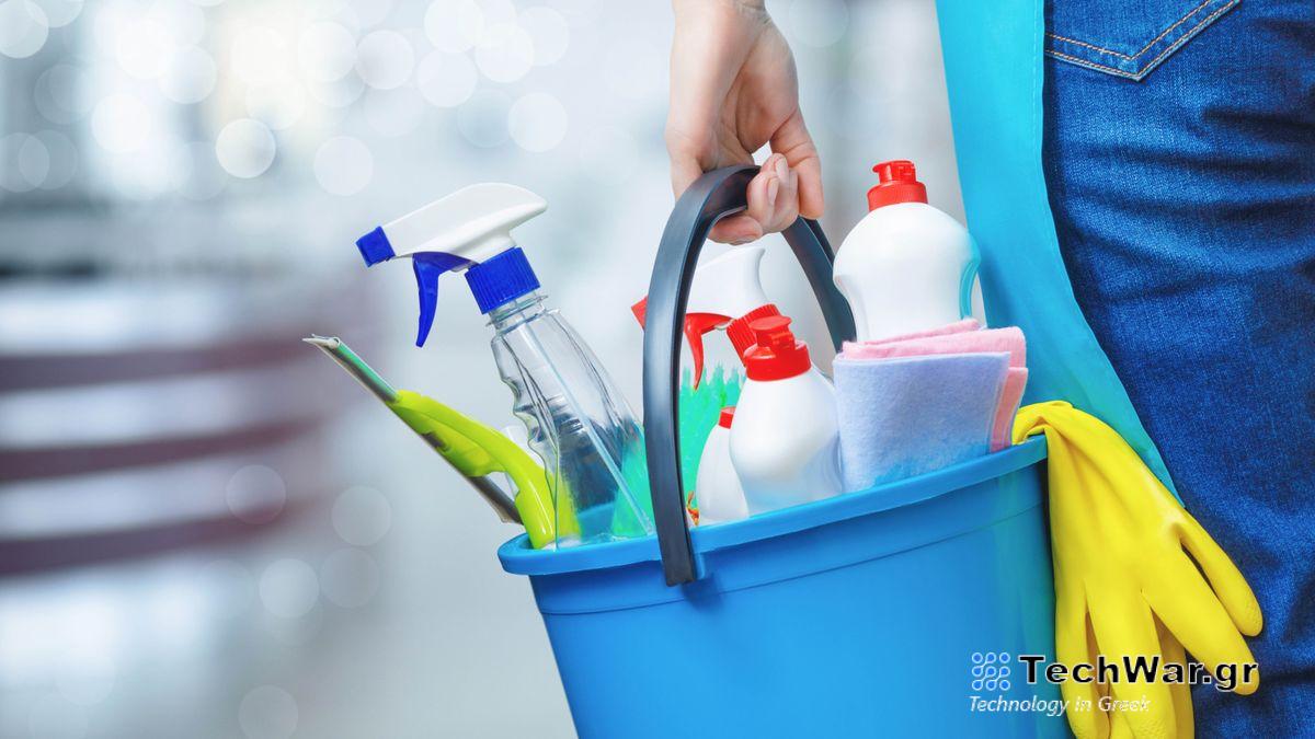 Cleaning equipment being carried in a bucket including a squeegee, cloths and spray bottles