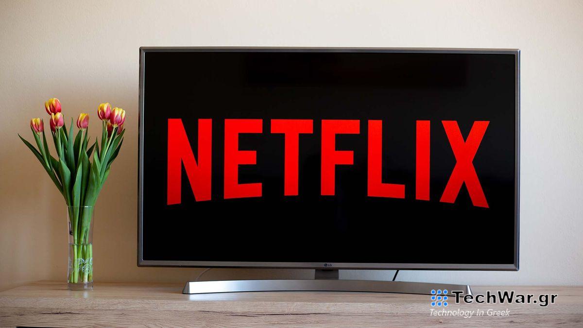 Netflix logo on a TV screen next to a vase of flowers