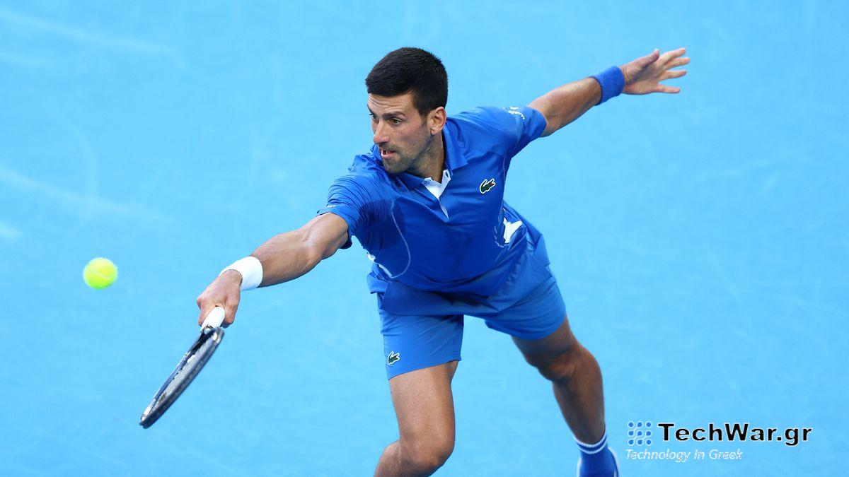 Novak Djokovic of Serbia, wearing royal blue tennis outfit, plays a lunging backhand on a blue court just prior to the Australian Open 2024