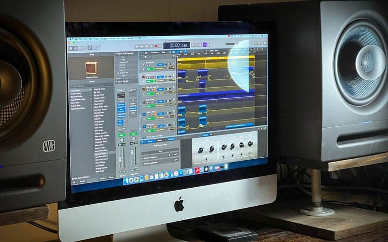 Two Eris Pro 8 studio monitors flanking a Mac desktop computer with a digital audio workspace open.