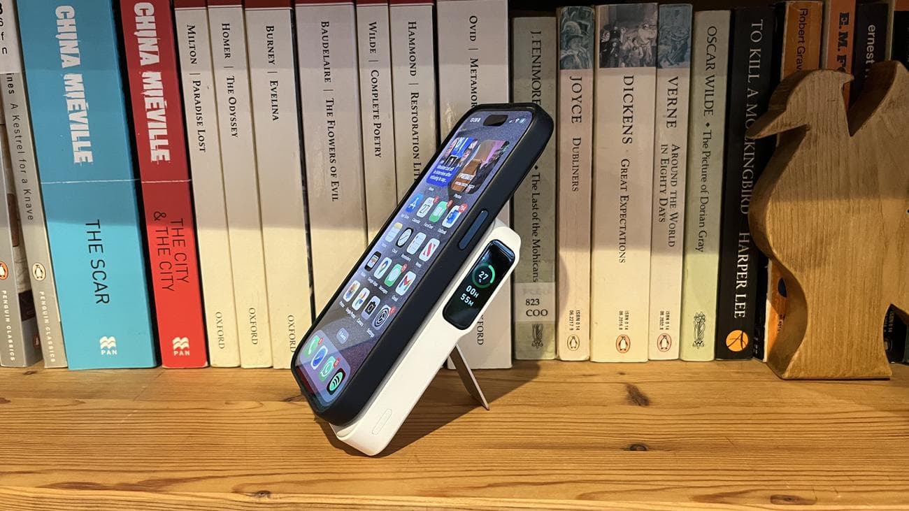 Το Anker MagGo Power Bank (10K) συνδεδεμένο με ένα iPhone 15 Pro σε ένα ξύλινο ράφι