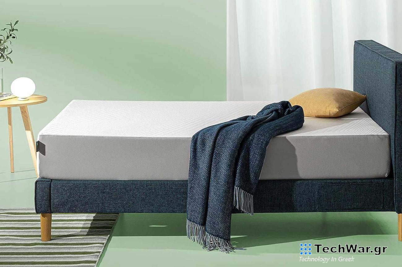 A white mattress on a blue bed in a green room.