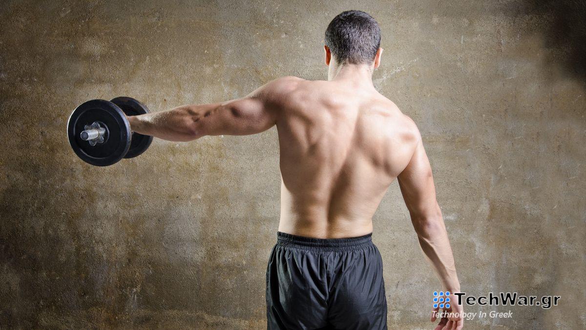 Man with back to camera performing single-arm dumbbell lateral raise left arm