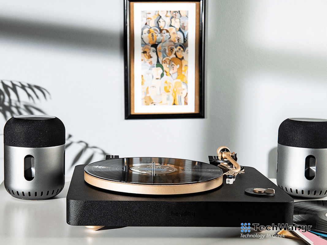 A turntable flanked by two Kapsule wireless speakers