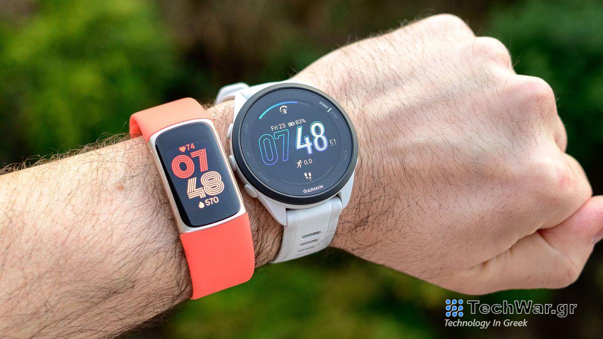 Fitbit Charge 6 and Garmin Forerunner 165 worn on the same wrist. 