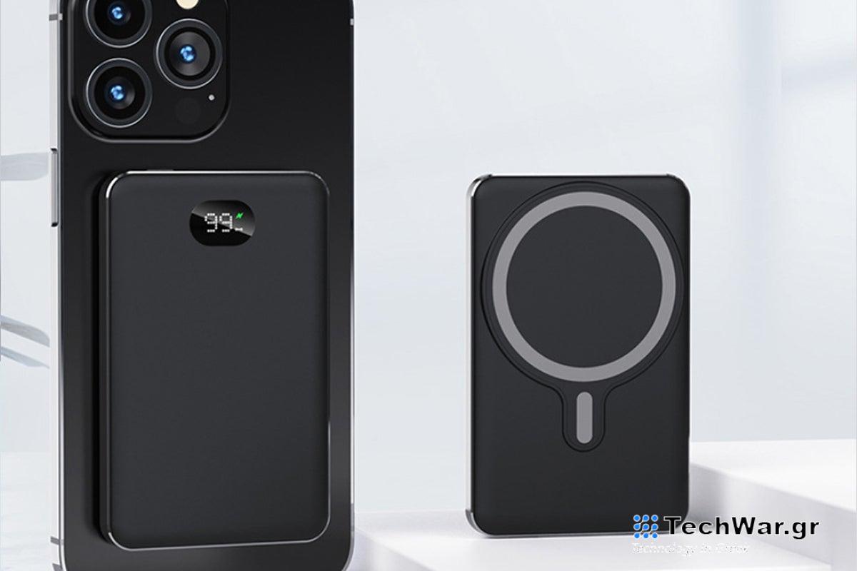 A wireless battery charger standing on a table next to an iPhone