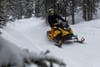 ένα snowmobile οδηγεί ένα κίτρινο snowmobile στο δάσος