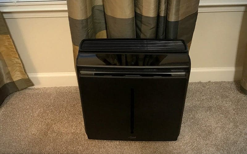 Black-rectangular-Rabbit A3 air purifier on carpet in front of curtains