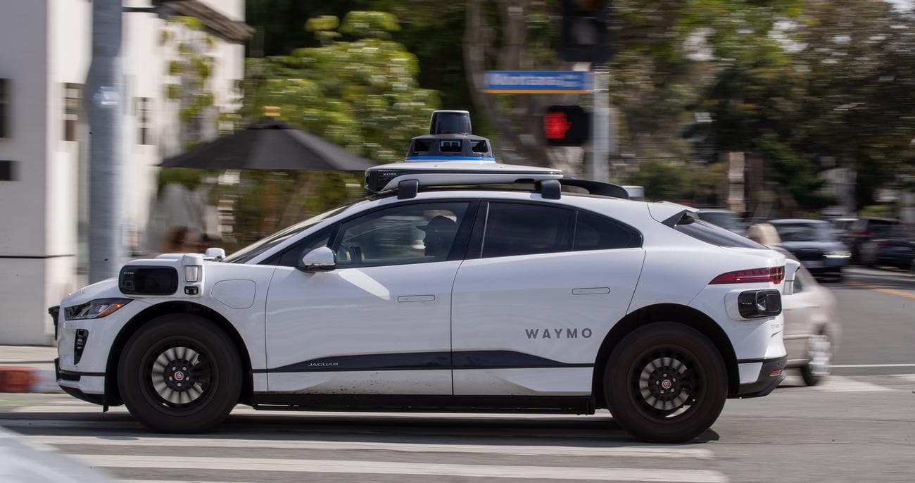 Ένα αυτόνομο όχημα Waymo που λειτουργεί σε δεντρόφυτο δρόμο στη Σάντα Μόνικα.