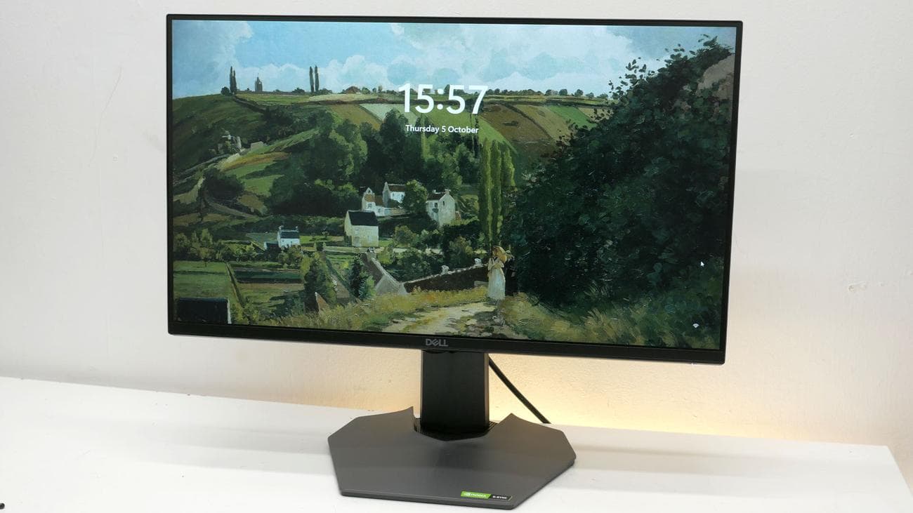 Εικόνα ανασκόπησης του Dell G2524H που δείχνει το μπροστινό μέρος της οθόνης με την προφύλαξη οθόνης ορατή πίσω από την ώρα.