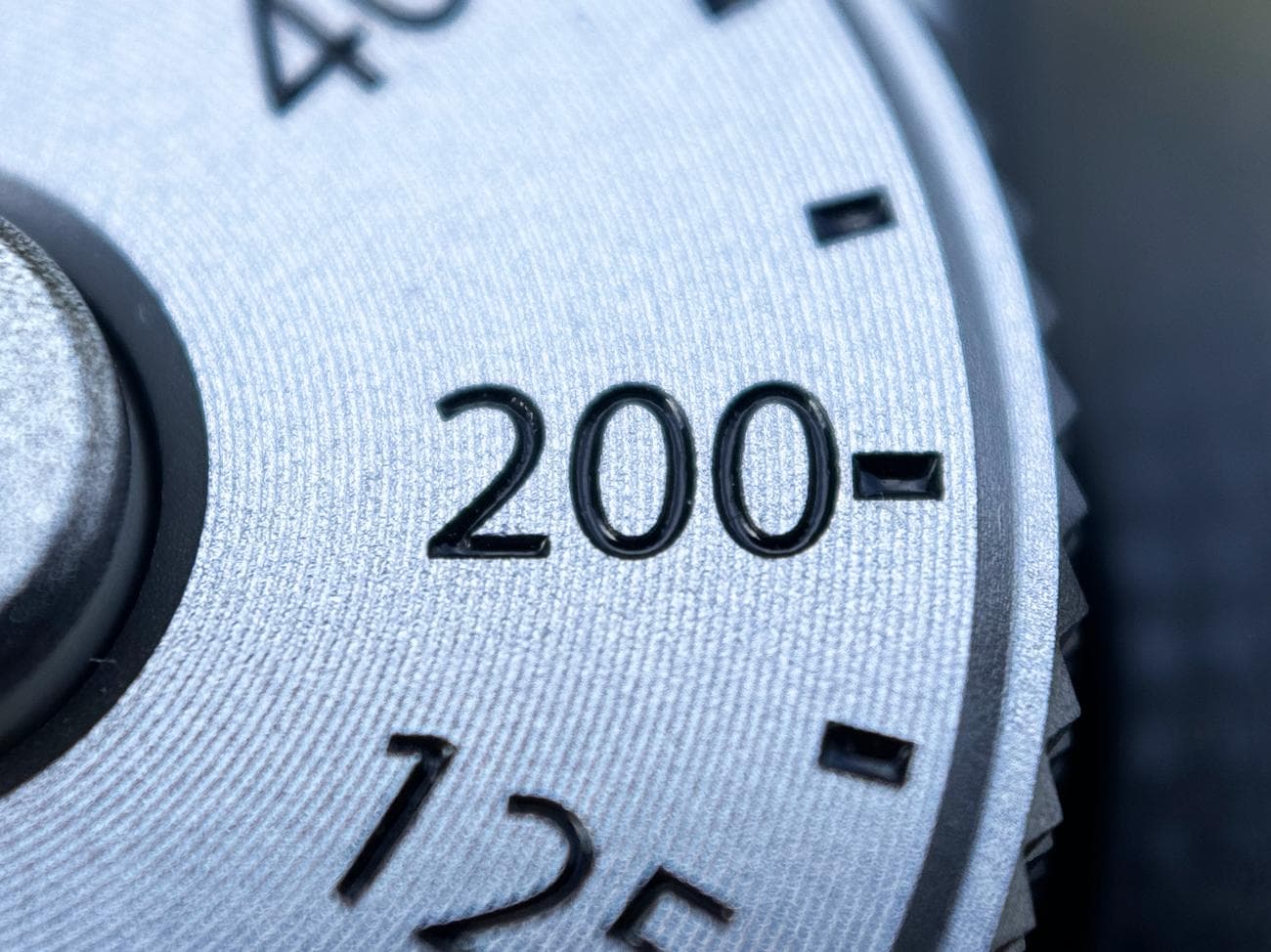 Μια κοντινή φωτογραφία ενός ασημί καντράν κάμερας που τραβήχτηκε σε ένα iPhone 15 Pro χρησιμοποιώντας τον μακρο φακό Sandmarc