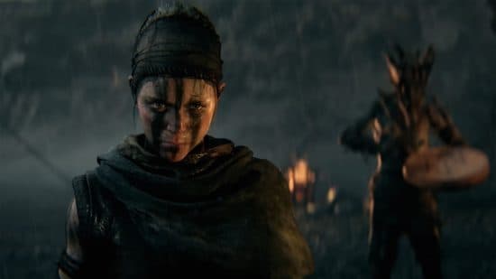 Senua's Saga: Hellblade 2 ημερομηνία κυκλοφορίας: Η Senua κοιτάζει απειλητικά μπροστά της, ενώ μια φωτιά καίει στο βάθος