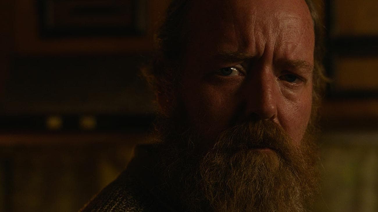 Μια κοντινή φωτογραφία ενός γενειοφόρου άνδρα που φαίνεται αβέβαιος.