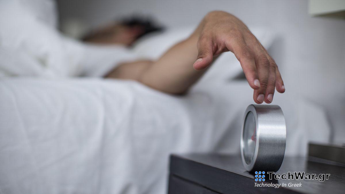 Aman reaches out of bed to turn off his alarm clock