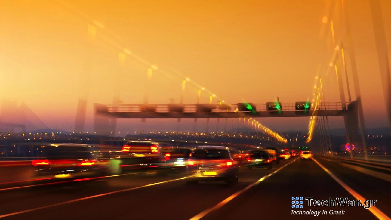 High traffic road with signs and light trails on sunset