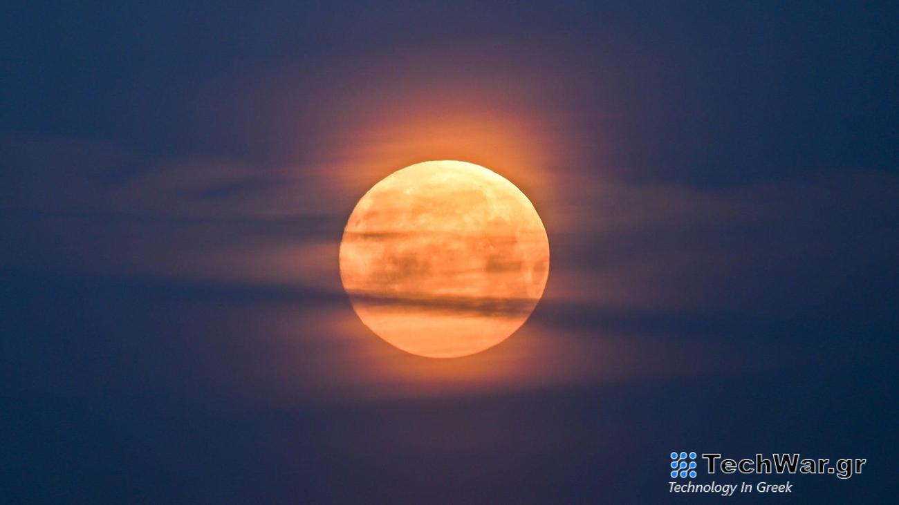 a full moon with some clouds obscuring it